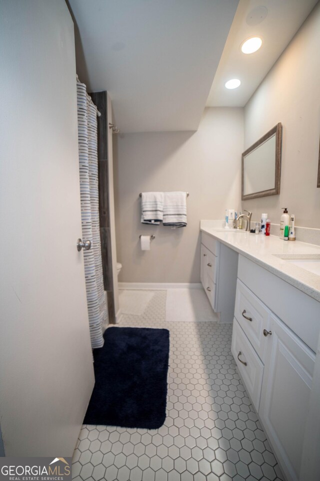 bathroom with tile patterned flooring, vanity, and toilet