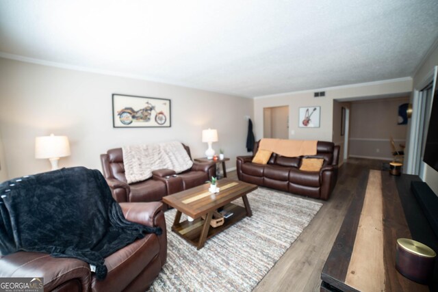 living room with wood-type flooring and crown molding