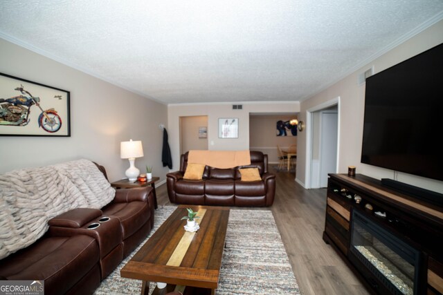 living room featuring hardwood / wood-style flooring, a notable chandelier, and a textured ceiling