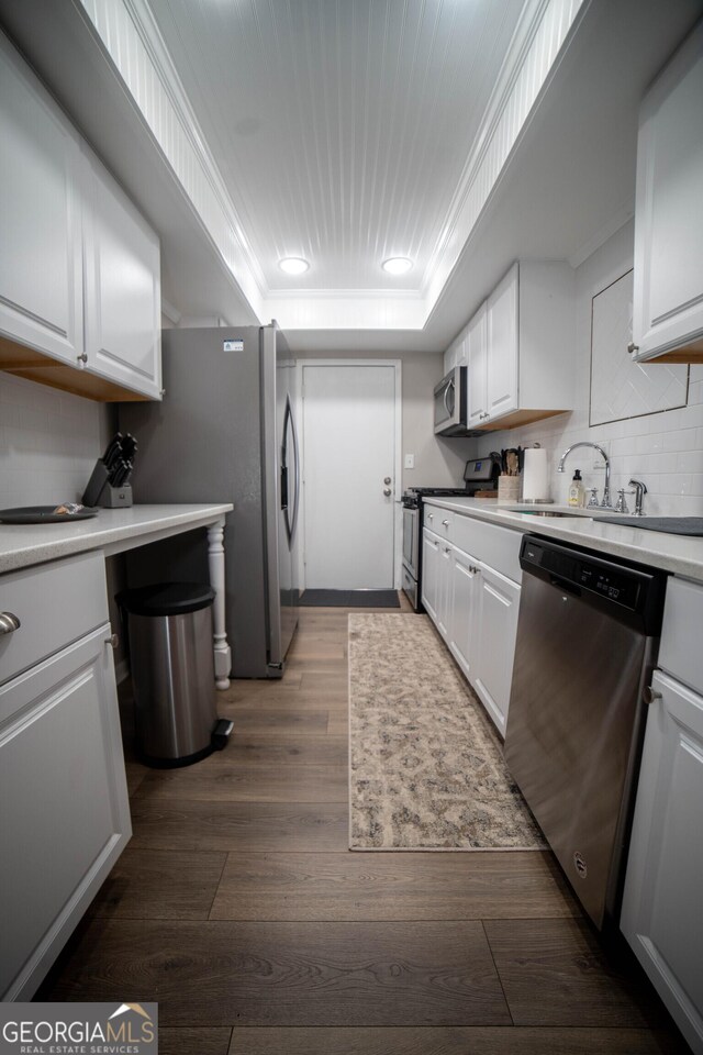 kitchen featuring dark hardwood / wood-style floors, sink, stainless steel appliances, and white cabinets