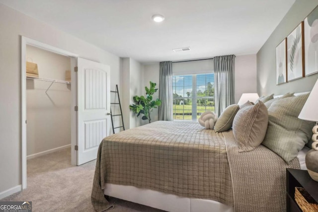 carpeted bedroom with a spacious closet and a closet