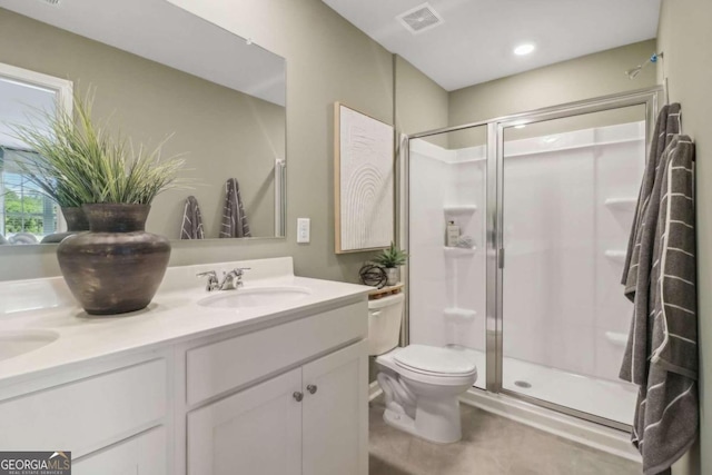 bathroom featuring vanity, toilet, and a shower with door