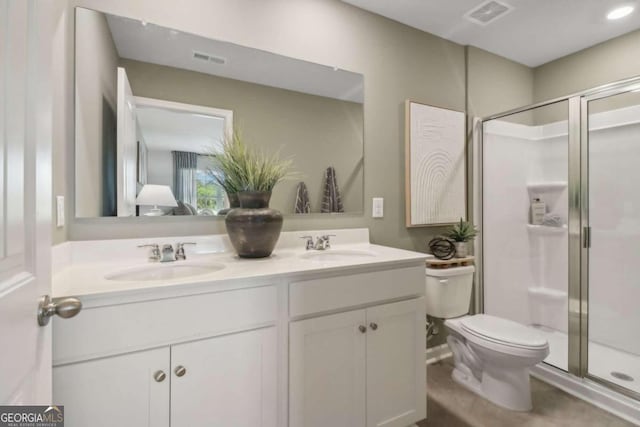 bathroom with an enclosed shower, vanity, and toilet