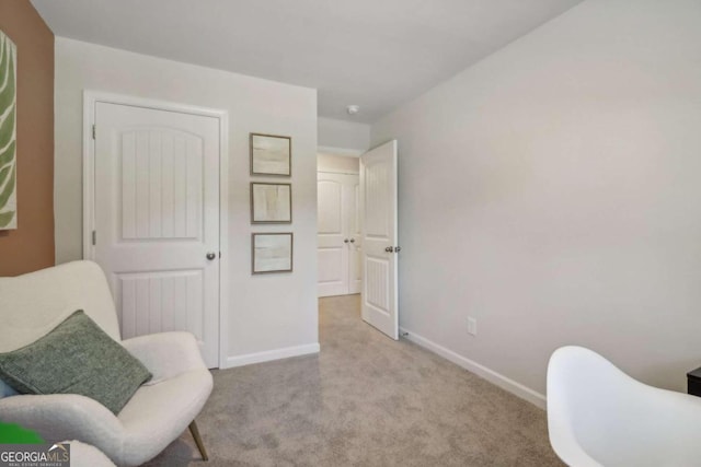 sitting room featuring light colored carpet