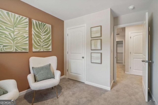 sitting room featuring light carpet