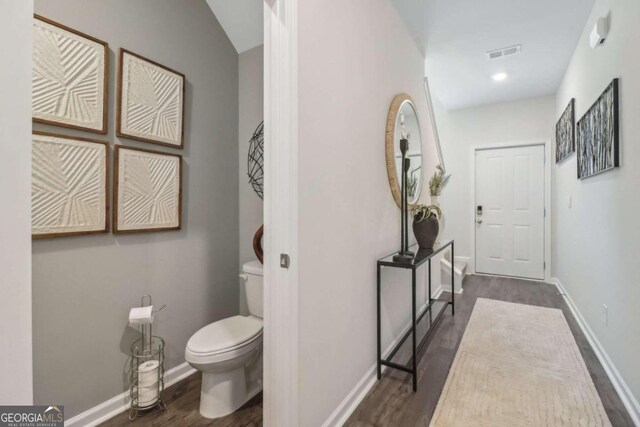 bathroom featuring wood-type flooring and toilet