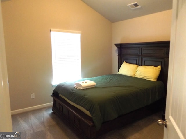 bedroom with dark carpet and vaulted ceiling