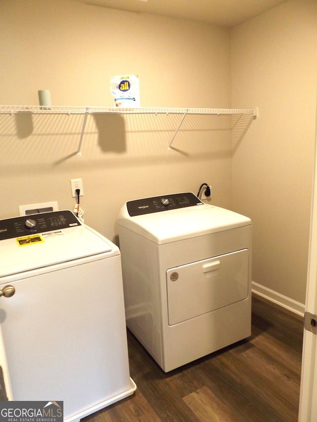 clothes washing area featuring washing machine and clothes dryer and dark hardwood / wood-style floors