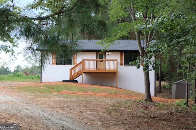 rear view of property featuring a storage shed