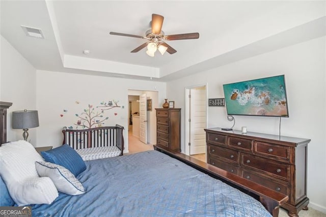 bedroom featuring ceiling fan, a raised ceiling, and visible vents