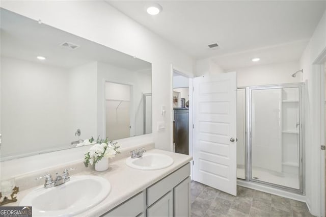 bathroom with a stall shower, a sink, recessed lighting, and double vanity