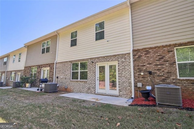 back of house with a yard, a patio area, central AC, and brick siding