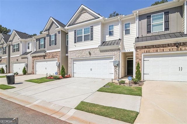 townhome / multi-family property featuring a garage, brick siding, concrete driveway, a residential view, and a standing seam roof