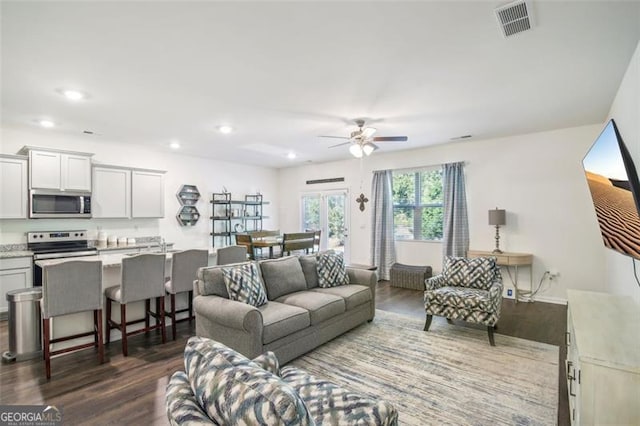 living area featuring ceiling fan, visible vents, dark wood-type flooring, and recessed lighting