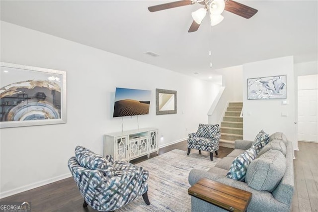 living area featuring ceiling fan, wood finished floors, visible vents, baseboards, and stairway