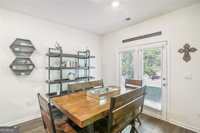 dining room with wood finished floors, visible vents, and baseboards