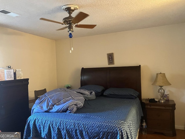 bedroom with a textured ceiling and ceiling fan