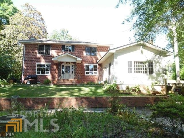 rear view of house featuring a lawn