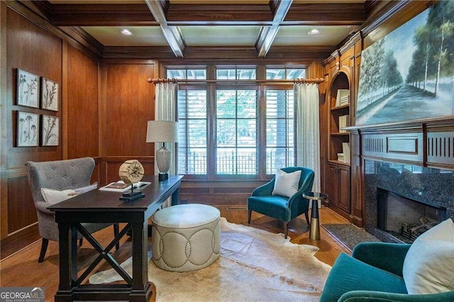 home office featuring coffered ceiling, beamed ceiling, a high end fireplace, wood walls, and wood-type flooring