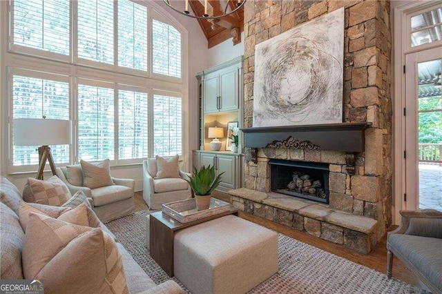 living room featuring a stone fireplace, hardwood / wood-style floors, and a healthy amount of sunlight