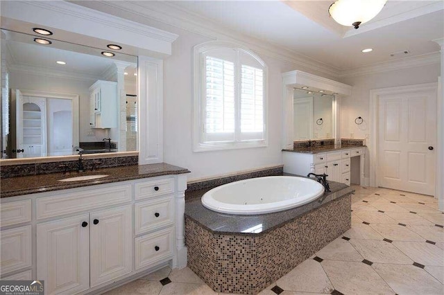 bathroom with tiled tub, vanity, and crown molding