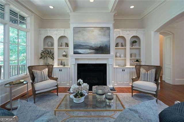 living room with a wealth of natural light, hardwood / wood-style floors, and built in features