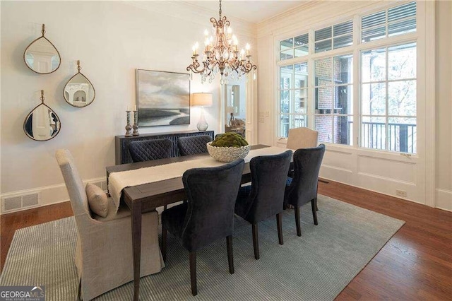 dining area featuring dark wood-type flooring and a notable chandelier