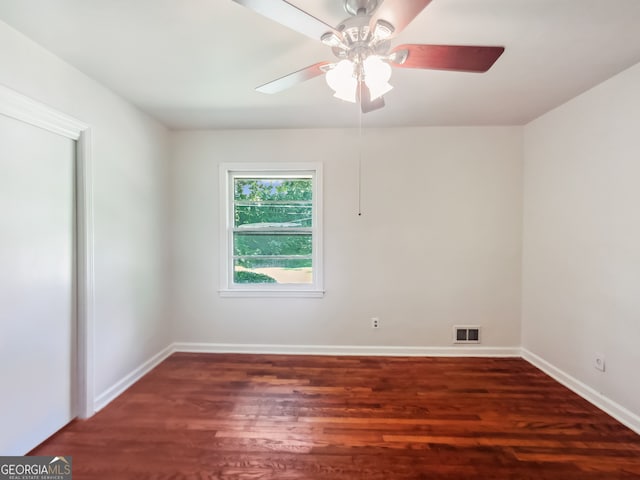 spare room with dark wood-type flooring and ceiling fan