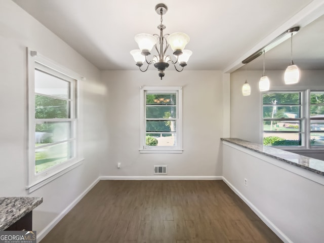 unfurnished dining area with a notable chandelier and dark hardwood / wood-style flooring