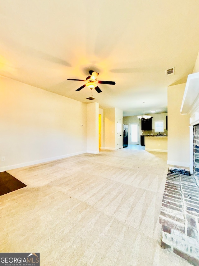 unfurnished living room featuring light carpet and ceiling fan