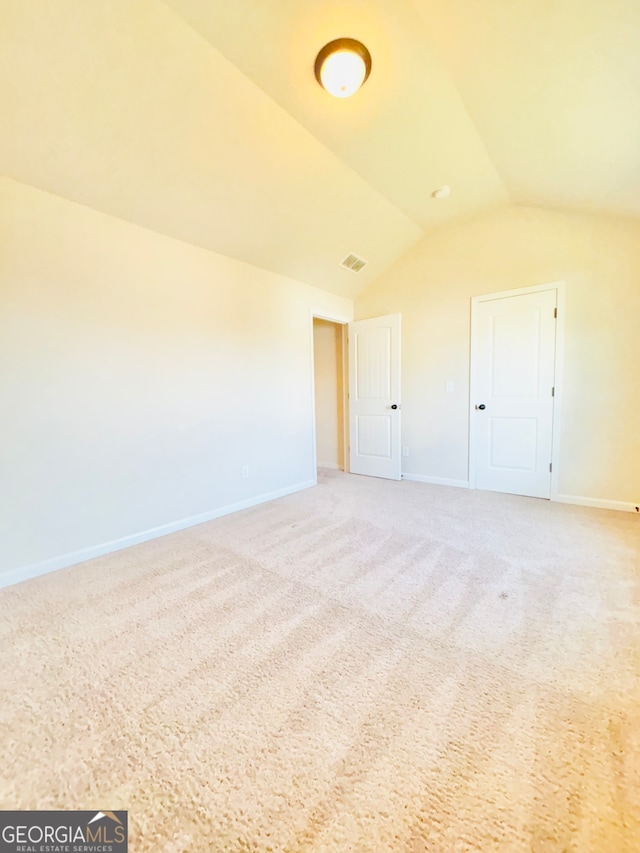 carpeted spare room with lofted ceiling