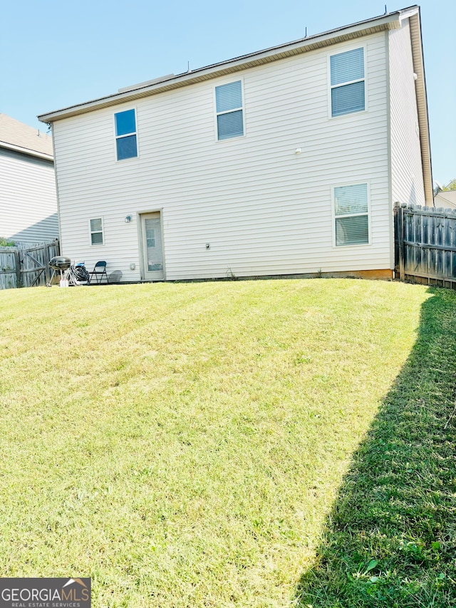 rear view of house with a yard