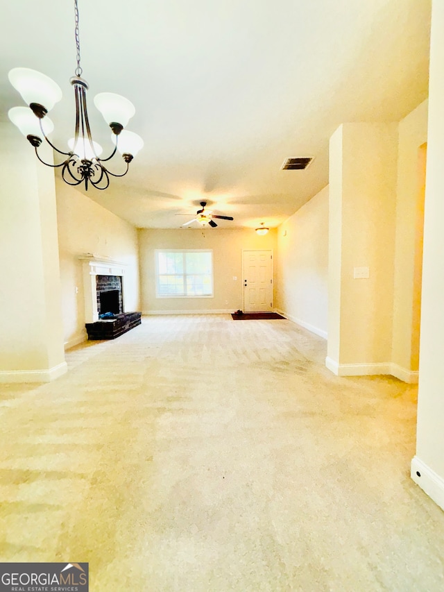 unfurnished living room featuring carpet flooring, ceiling fan with notable chandelier, and a fireplace