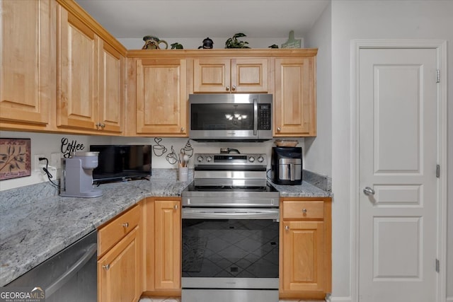 kitchen featuring light stone counters and appliances with stainless steel finishes