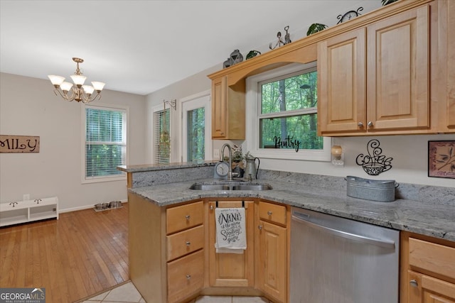 kitchen featuring plenty of natural light, light hardwood / wood-style flooring, stainless steel dishwasher, and sink