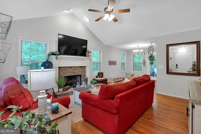 living room featuring plenty of natural light, vaulted ceiling, hardwood / wood-style floors, and a fireplace