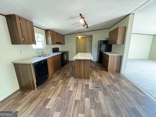 kitchen with a textured ceiling, black appliances, dark hardwood / wood-style flooring, a kitchen island, and sink