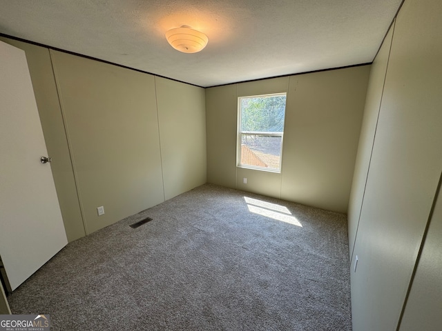 unfurnished bedroom featuring a closet, a textured ceiling, and carpet floors