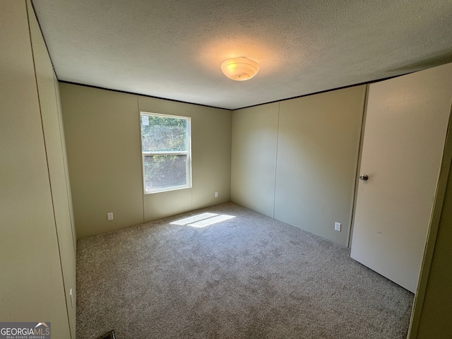 unfurnished bedroom featuring a textured ceiling, a closet, and carpet floors