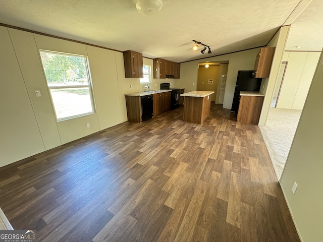 kitchen featuring a textured ceiling, dark wood-type flooring, sink, and dishwasher