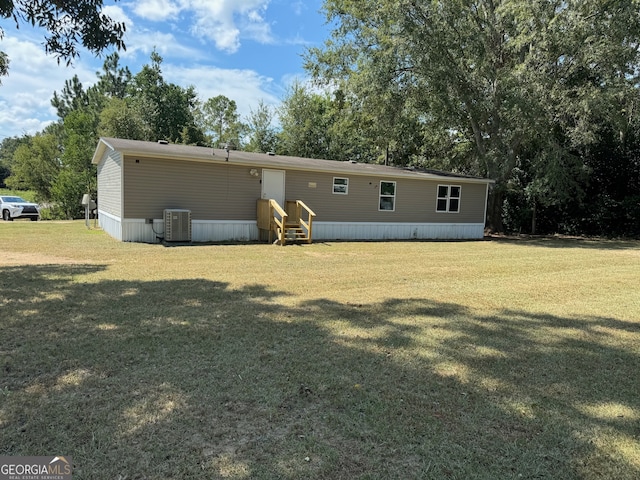 rear view of property with a lawn and central AC unit