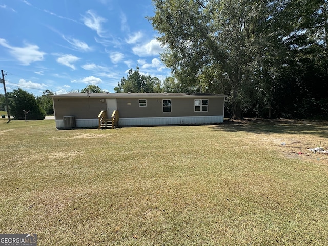 back of property with a lawn and central AC