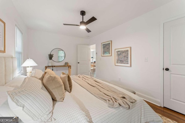 bedroom with multiple windows, hardwood / wood-style flooring, and ceiling fan