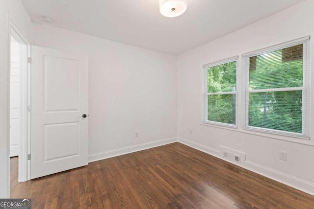 spare room with dark hardwood / wood-style flooring