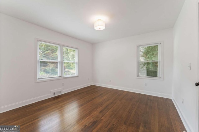 unfurnished room with dark hardwood / wood-style flooring