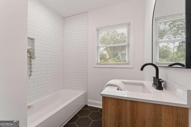 bathroom featuring tiled shower / bath combo, vanity, plenty of natural light, and tile patterned flooring