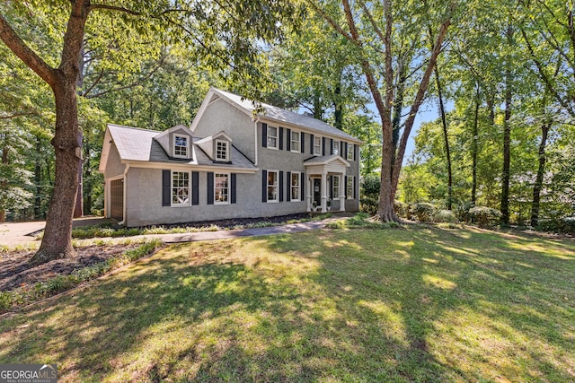 colonial house with a garage and a front lawn