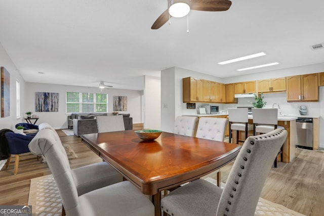 dining room featuring light wood-type flooring, ceiling fan, and sink