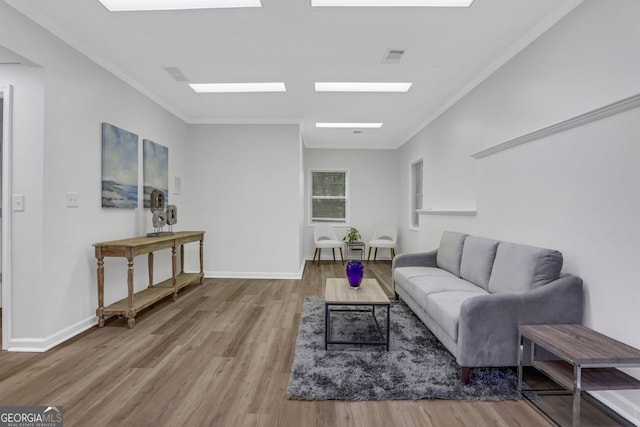 living room with wood-type flooring and ornamental molding