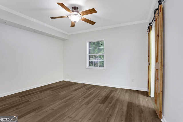 unfurnished room with a barn door, ornamental molding, dark wood-type flooring, and ceiling fan